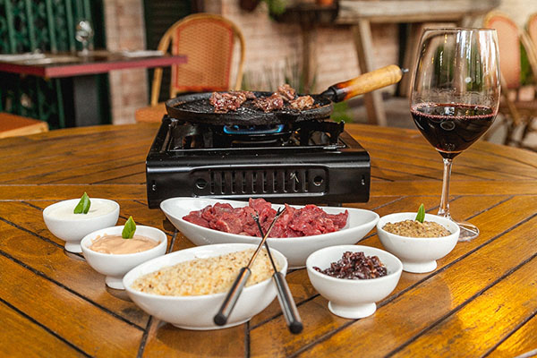 CAFE DAS 5_Fondue de carne na chapa, que acompanha farofa de gremolata, molhos rosê, de cebola caramelizada de alho e mostarda dijon, com vinho tinto_Foto_Felipe Menezes_01